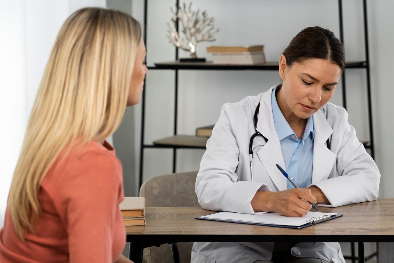 Médica explicando resultado de exame de sangue para paciente durante consulta