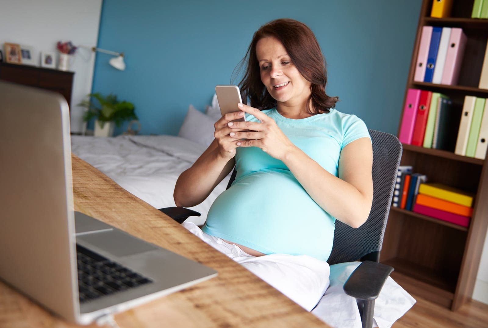 Gestante usando o celular para acompanhar as orientações do endocrinologista entre as consultas