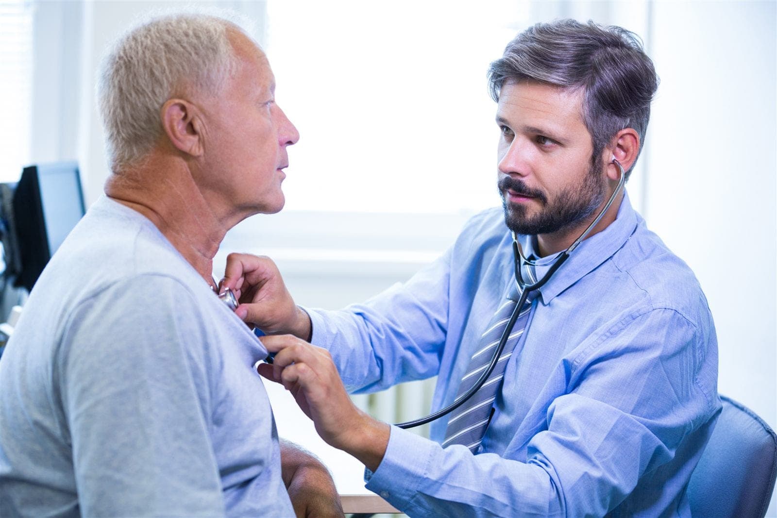 Médico avaliando paciente com dor no peito em consulta