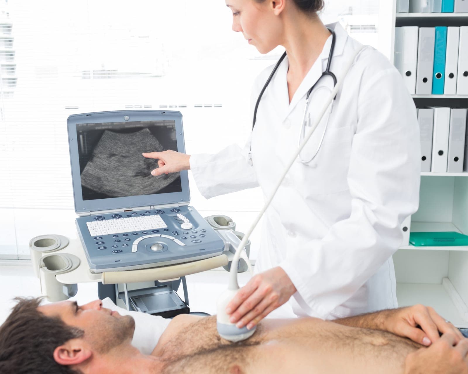 Médico realizando ecocardiograma com transdutor de ultrassom no tórax do paciente