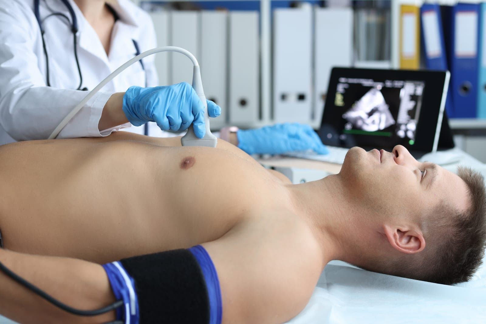 Paciente realizando exame de ecocardiograma em consultório com acompanhamento médico