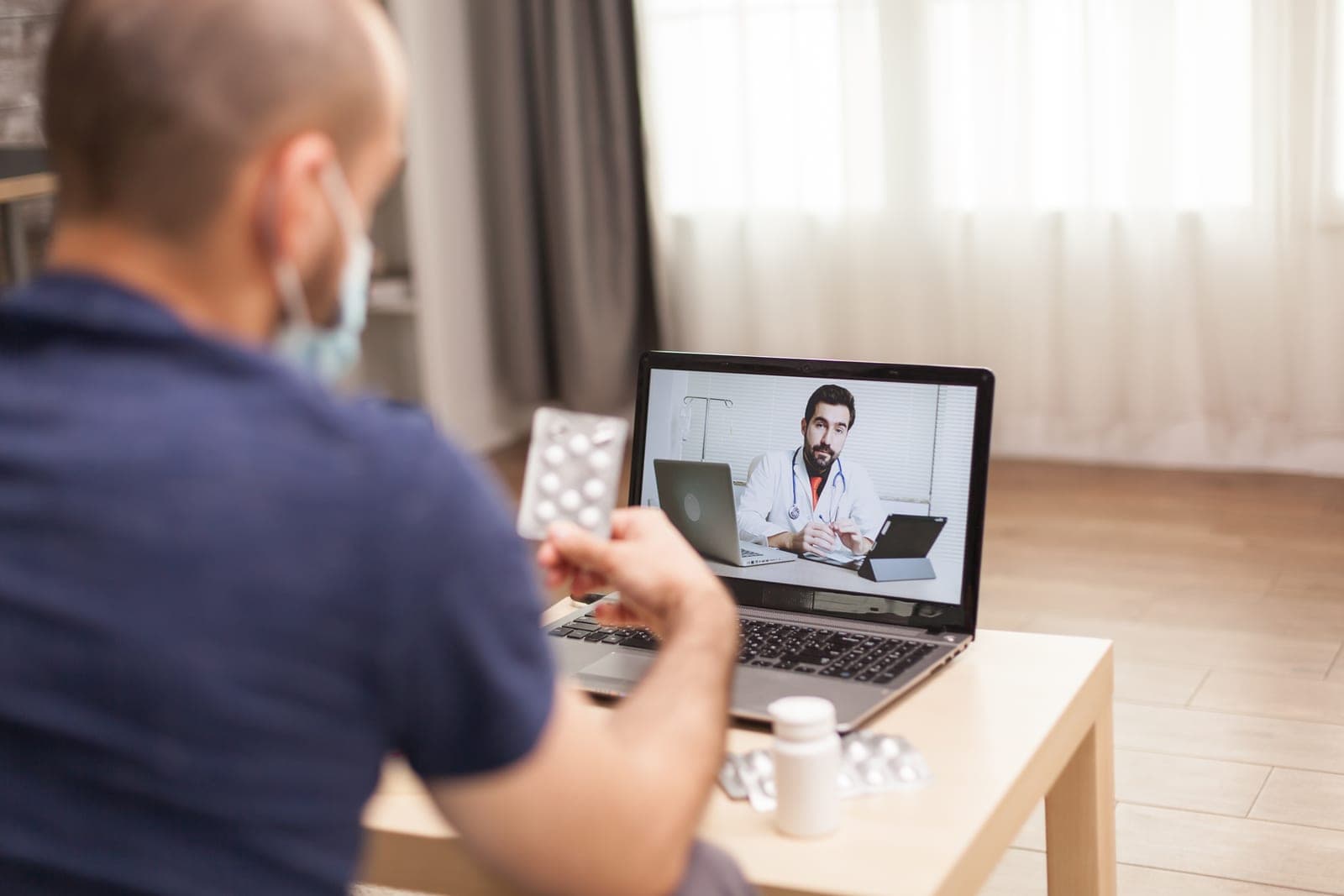 Paciente em teleconsulta pelo laptop recebendo orientação médica