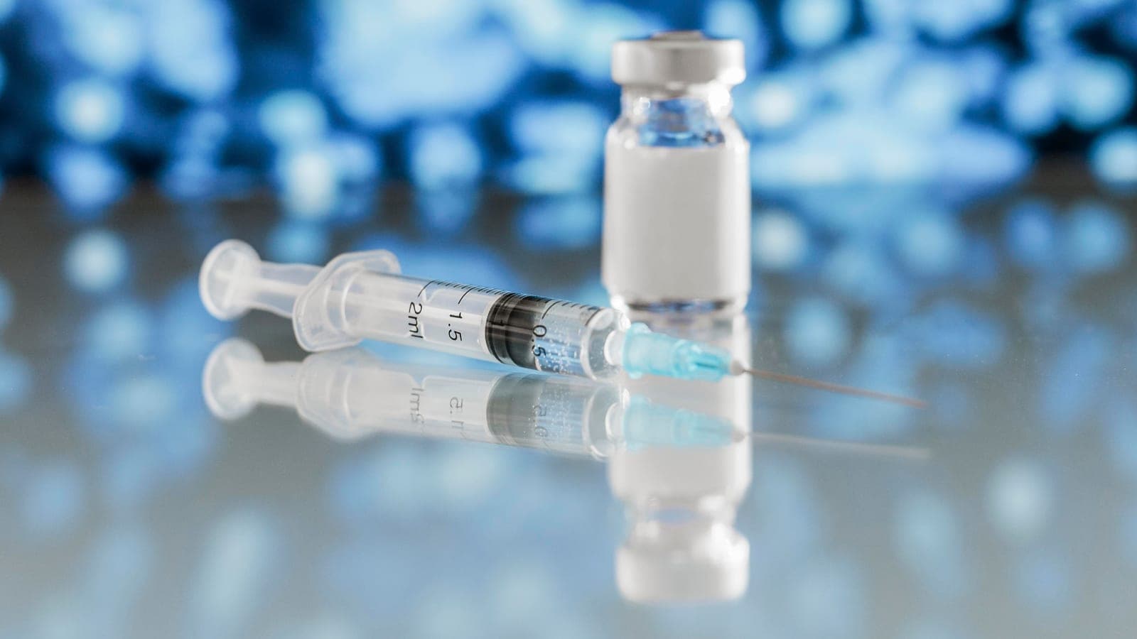 Frasco de vacina e seringa sobre superfície clínica