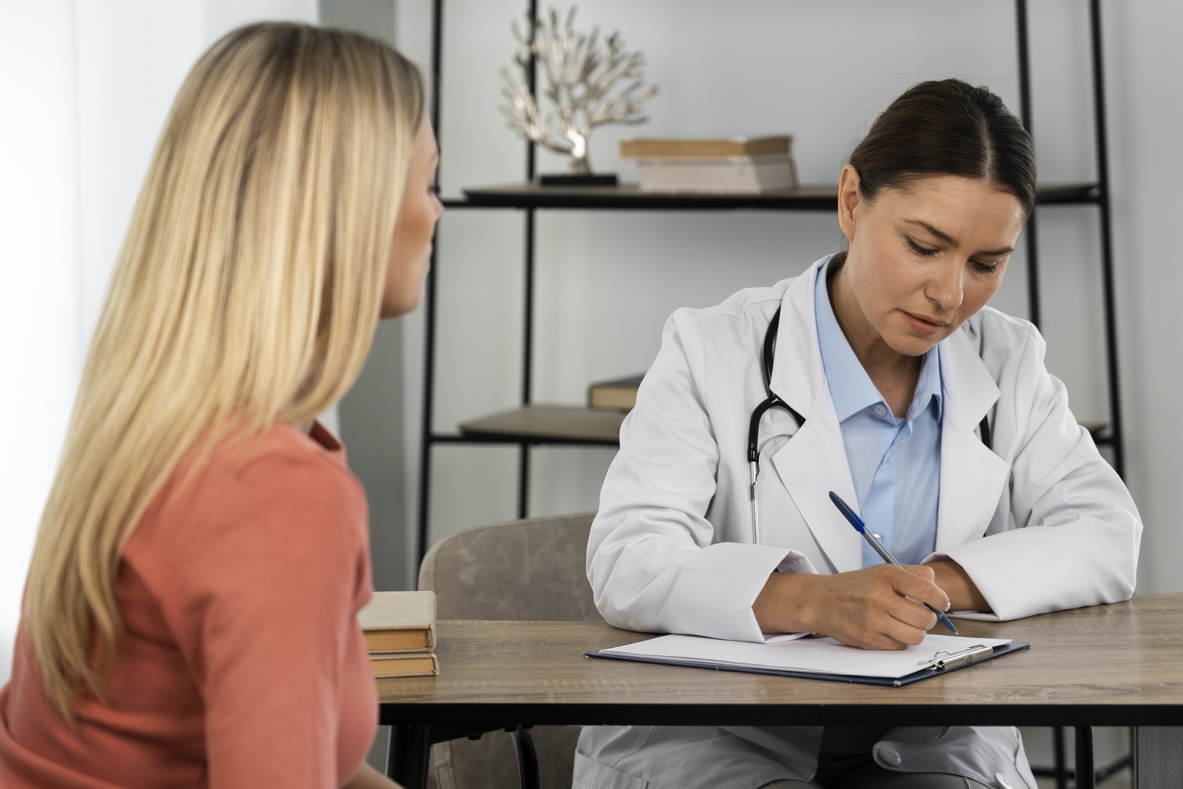 Médica explicando resultado de exame de sangue para paciente durante consulta